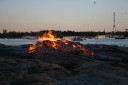 A smaller bonfire on shore..