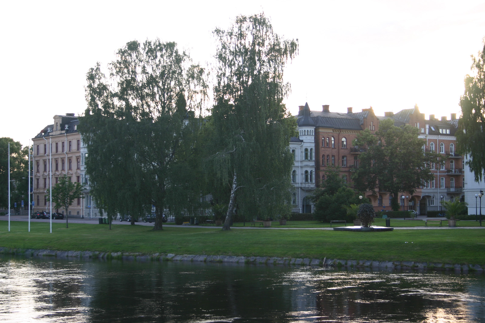 Old stately buildings along a green riverside